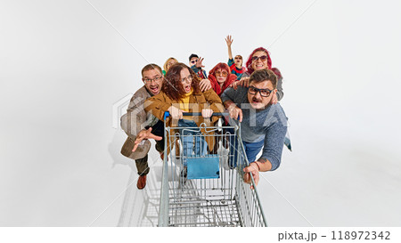 Group of emotional people dressed in stylish autumn outfits, fighting for the best shopping deals, pushing shopping cart forward Group of emotional people dressed in stylish autumn outfits, fighting for the best shopping deals, pushing shopping cart forward 118972342