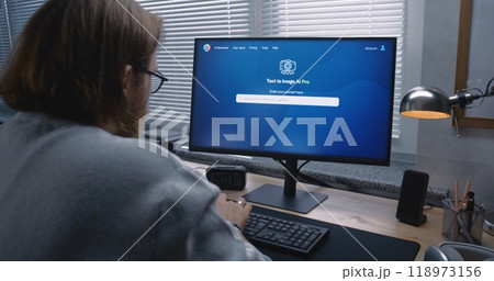 Adult man enters prompt in AI chatbot on personal computer 118973156