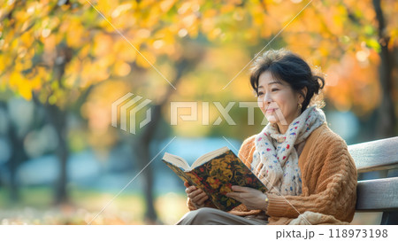 公園のベンチで読書する女性 118973198