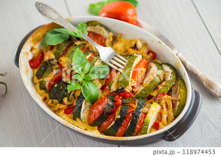 prepared baked zucchini and tomatoes in circles in a ceramic form, vegetable snack 118974453