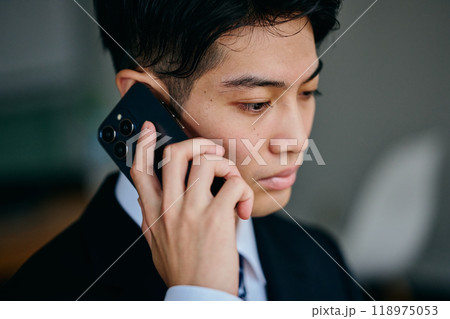 電話をする20代の若い男性 電話をする20代の若い男性 118975053