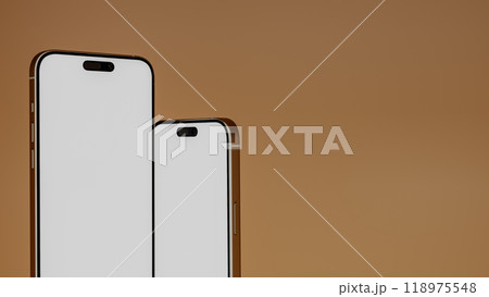 Two smartphones blank screen close up with warm gradient background, 3d render 118975548