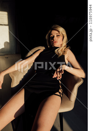 Portrait of a slender blonde woman in a black evening dress 118975944
