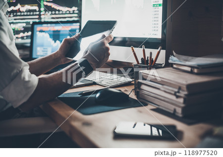 Using modern technologies at work. Close-up of young businessman holding digital tablet while sitting at the desk in creative office 118977520