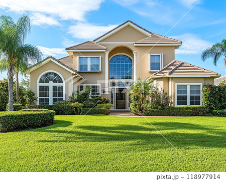 A beautiful home with a large front yard and blue sky in the background, representing the high-end residential real estate market of North America.  118977914