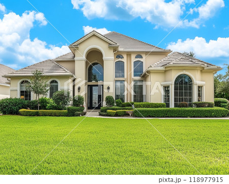 A beautiful home with a large front yard and blue sky in the background, representing the high-end residential real estate market of North America.  118977915