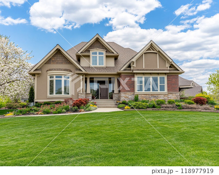 A beautiful home with a large front yard and blue sky in the background, representing the high-end residential real estate market of North America.  118977919
