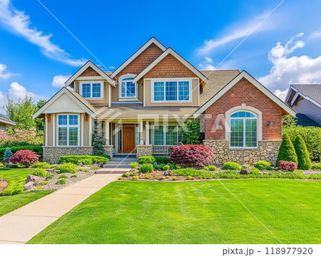 A beautiful home with a large front yard and blue sky in the background, representing the high-end residential real estate market of North America.  118977920