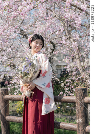さくら咲く街を袴姿で歩く若い女性 118978225