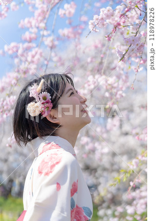 さくら咲く街を袴姿で歩く若い女性 118978226