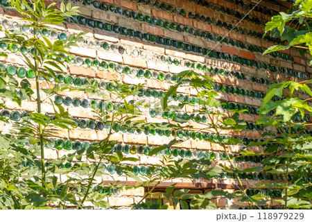 The wall of the house is made of bricks and glass green bottles. The wall of the house is made of bricks and glass green bottles. 118979229