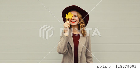 Autumn portrait beautiful happy smiling woman with yellow maple leaves, stylish joyful girl in hat 118979603