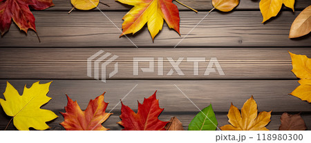 Wooden table with colorful autumn leaves on it creating a frame around the background copy space for advertising text. Top view 118980300