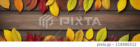 Wooden table with colorful autumn leaves on it creating a frame around the background copy space for advertising text. Top view 118980312