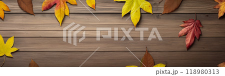 Wooden table with colorful autumn leaves on it creating a frame around the background copy space for advertising text. Top view 118980313