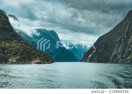 Cruise with majestic mountain and waterfall flowing in Milford Sound, New Zealand Cruise with majestic mountain and waterfall flowing in Milford Sound, New Zealand 118980436