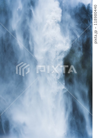 Moody waterfall flowing in tropical rainforest at Milford Sound 118980440