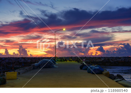Colorful sunrise sky over stone jetty Colorful sunrise sky over stone jetty 118980540