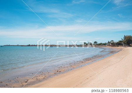 Tropical sea beach with fishing boat by stone jetty in summer 118980563