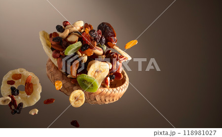 Dried tropical fruits with various nuts and raisins in motion. 118981027
