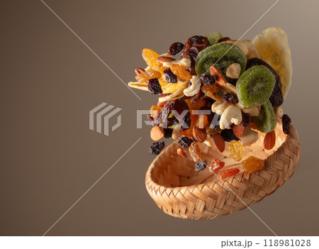 Dried tropical fruits with various nuts and raisins in motion. Dried tropical fruits with various nuts and raisins in motion. 118981028