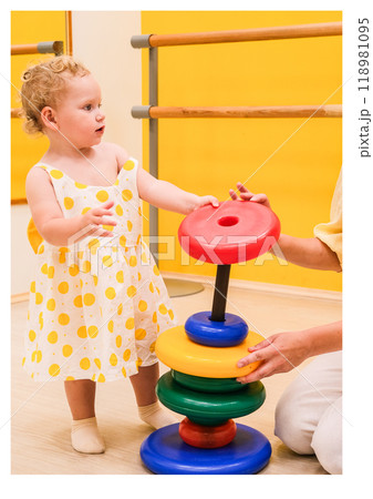 Beautiful blonde baby girl playing in kindergarten 118981095