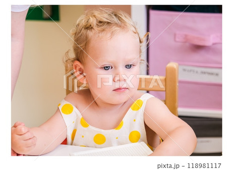 Beautiful blonde baby girl playing in kindergarten 118981117