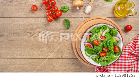 Spinach salad with fresh tomato, onion, green leaves mix. Healthy vegan food. Top view Spinach salad with fresh tomato, onion, green leaves mix. Healthy vegan food. Top view 118981258