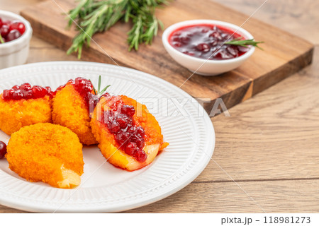 Baked or fried Camembert or brie cheese with cranberry and rosemary sauce on wooden Table Baked or fried Camembert or brie cheese with cranberry and rosemary sauce on wooden Table 118981273