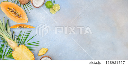 summer tropical fruits papaya, pineapple, coconut, lime and leaves on a blue background top view. copy space. Summer background summer tropical fruits papaya, pineapple, coconut, lime and leaves on a blue background top view. copy space. Summer background 118981327