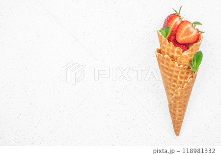 fresh strawberries and icecream cones, berry fruit in waffle cone on a light background, top view. copy space fresh strawberries and icecream cones, berry fruit in waffle cone on a light background, top view. copy space 118981332