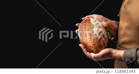 male baker holds homemade freshly baked rye gluten free bread, Long banner format. copy space for text 118981343