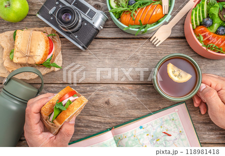 a man snacking on a sandwich and tea while planning a hiking route. travel concept 118981418