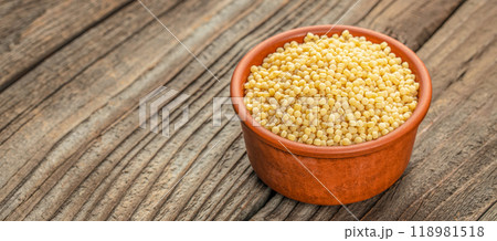 Dry ptitim. Toasted pasta ptitim on a wooden board. Food recipe background. Close up 118981518