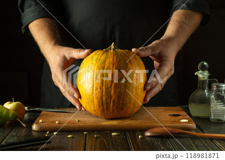 A large pumpkin on the kitchen counter before cooking by a chef. The concept of a vegetable diet or cooking a national dish 118981871