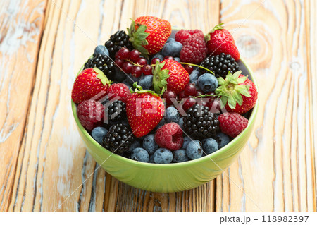 Mix of ripe colorful berries in bowl photography . Blueberry , strawberry , raspberry , blackberry and red currant . Top view Mix of ripe colorful berries in bowl photography . Blueberry , strawberry , raspberry , blackberry and red currant . Top view 118982397