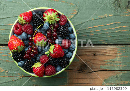 Mix of ripe colorful berries in bowl photography . Blueberry , strawberry , raspberry , blackberry and red currant . Top view Mix of ripe colorful berries in bowl photography . Blueberry , strawberry , raspberry , blackberry and red currant . Top view 118982399
