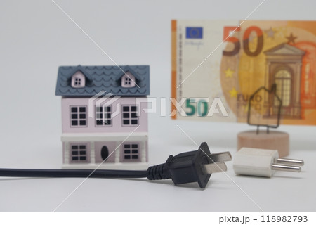 Electric cable and banknotes against the background of a toy model house 118982793