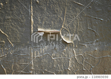 Detailed texture of aged plaster on an old wall revealing layers of history and unique patterns in natural light 118983030