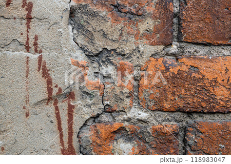 Texture of an aged brick wall with peeling plaster revealing the beauty of decay and urban history Texture of an aged brick wall with peeling plaster revealing the beauty of decay and urban history 118983047