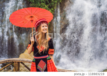 A female tourist dressed in the traditional dress of the inhabitants of the Vietnamese mountains, the Hmong. Woman in Sapa in the fog, Northwest Vietnam. Vietnam travel concept. UNESCO heritage 118983219