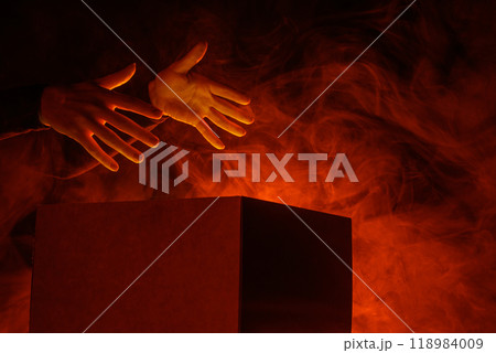 Man opens magic box with surprise on dark background, mystical box, surprise, halloween, monster box Man opens magic box with surprise on dark background, mystical box, surprise, halloween, monster box 118984009