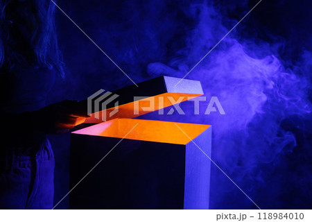 Man opens magic box with surprise on dark background, mystical box, surprise, halloween, monster box Man opens magic box with surprise on dark background, mystical box, surprise, halloween, monster box 118984010