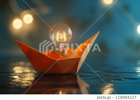 Orange paper boat floating on water with lit light bulb symbolizing ideas 118984227