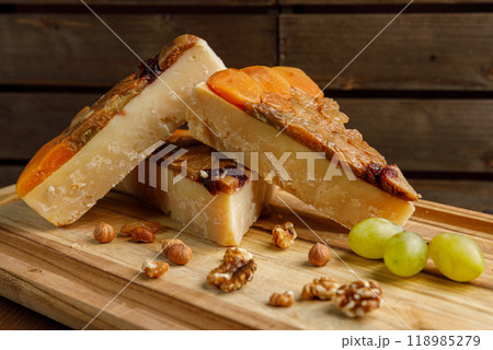 An Elegant Artisan Cheese Platter Accompanied by Nutty Grapes on a Rustic Wooden Board An Elegant Artisan Cheese Platter Accompanied by Nutty Grapes on a Rustic Wooden Board 118985279