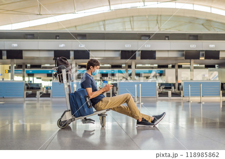 Man in mask at empty airport at check in in coronavirus quarantine isolation, returning home, flight cancellation, pandemic infection worldwide spread, travel restrictions and border shutdown Man in mask at empty airport at check in in coronavirus quarantine isolation, returning home, flight cancellation, pandemic infection worldwide spread, travel restrictions and border shutdown 118985862
