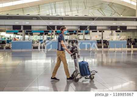 Man in mask at empty airport at check in in coronavirus quarantine isolation, returning home, flight cancellation, pandemic infection worldwide spread, travel restrictions and border shutdown Man in mask at empty airport at check in in coronavirus quarantine isolation, returning home, flight cancellation, pandemic infection worldwide spread, travel restrictions and border shutdown 118985867