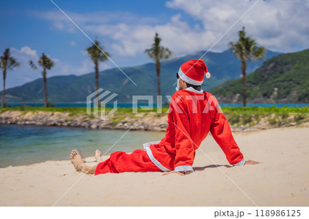 Santa Claus relaxing on sea beach - christmas or happy new year concept. Christmas in the tropics after quarantine was lifted Coronovirus COVID 19 concept 118986125