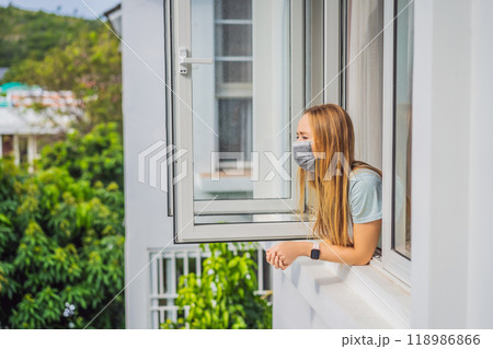 Extremly tired woman looking out the window, home alone. self-isolation at home, quarantine due to pandemic COVID 19. Mental health problems in self-isolation at home, quarantine, isolation, stay at 118986866