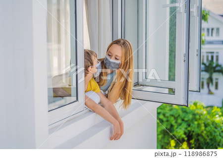 Extremly tired Mother and son looking out the window, home alone. self-isolation at home, quarantine due to pandemic COVID 19. Mental health problems in self-isolation at home, quarantine, isolation 118986875